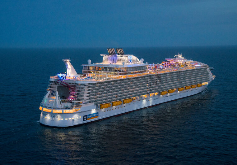 SY, Symphony of the Seas, Aerial view at night offshore Barcelona, Spain, on April 5, 2018, dusk, evening, starboard aft view, horizon, ship lights,